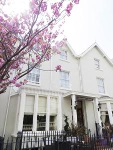 a white house with pink flowers in front of it at Seaclyffe Hotel Ltd in Llandudno