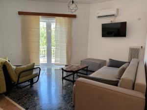 a living room with a couch and a tv at Goldy Centre Home in Rethymno Town