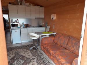 uma sala de estar com um sofá e uma mesa numa cozinha em Domek letniskowy Nad Stawami em Supraśl