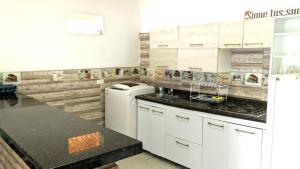 - une cuisine avec des placards blancs et un lave-linge/sèche-linge dans l'établissement Casa de descanso acacias meta, à Acacías