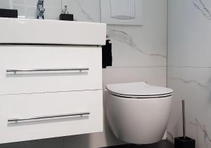 Baño blanco con aseo y lavamanos en Luxusferienwohnung mit Panoramablick in Köln Zentrum, en Colonia