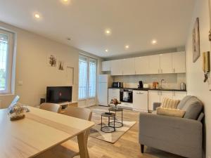 een keuken en een woonkamer met een tafel en een eetkamer bij Cozy appart' a deux pas de la gare - Cozy Houses in Palaiseau