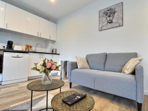 a living room with a couch and two tables at Cozy appart' a deux pas de la gare - Cozy Houses in Palaiseau