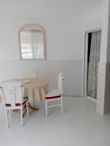 a white room with a table and chairs and a window at La casa blanca in La Pineda