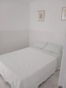 a white bed in a white room with a white wall at La casa blanca in La Pineda