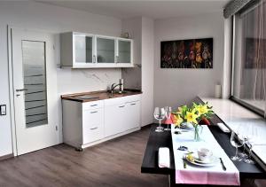 eine Küche mit einem Esstisch und eine Küche mit weißen Schränken in der Unterkunft Luxusferienwohnung mit Panoramablick in Köln Zentrum in Köln