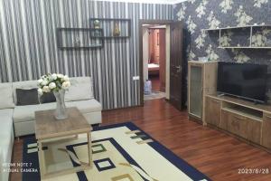 a living room with a couch and a tv at Elegant Condo next to Bazaar, close to the metro station, 9 in Tashkent