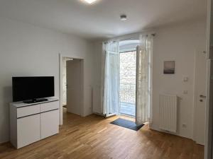 a living room with a flat screen tv on a dresser at Paky Appartements 00313 in Bruck an der Leitha