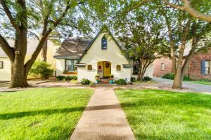 una casa con una puerta amarilla y césped verde en Renovated Lubbock Home - Walk to Texas Tech! en Lubbock