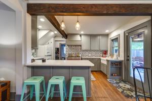 una cocina con una gran isla con taburetes verdes en Renovated Lubbock Home - Walk to Texas Tech!, en Lubbock