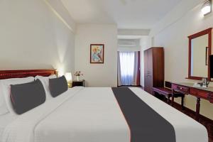 1 cama blanca grande en una habitación de hotel en Collection O Narendra Regency, en Punalūr