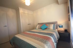 ein Schlafzimmer mit einem Bett mit einem blauen Kissen in der Unterkunft Yass Valley Stays - Easy self check-in in Yass