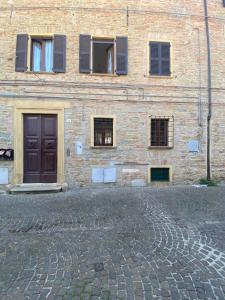 ceglany budynek z oknami i brązowymi drzwiami w obiekcie Casa Mimmi - Pesaro Centro/Mare w mieście Pesaro