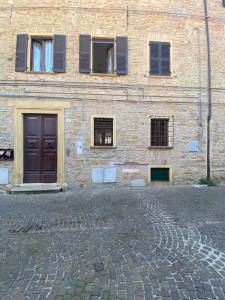 a brick building with windows and a brown door at La Casa di Erika - Pesaro Centro-Mare in Pesaro