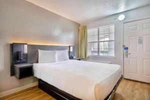 a large white bed in a room with a window at Studio 6-San Antonio, TX - Medical Center in San Antonio