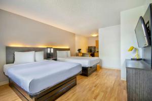 a hotel room with two beds and a flat screen tv at Studio 6-San Antonio, TX - Medical Center in San Antonio