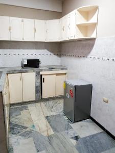 uma cozinha vazia com armários brancos e um frigorífico em OCEANIk SUITES & HOTEL em Guayaquil