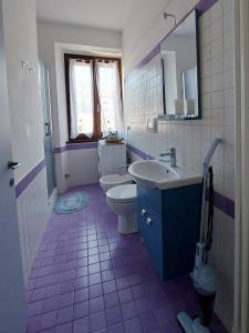 - fioletowo-białą łazienkę z toaletą i umywalką w obiekcie Casa Mimmi - Pesaro Centro/Mare w mieście Pesaro