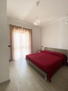 um quarto com uma cama grande e um cobertor vermelho em B&b Monticella Contursi Terme em Contursi Terme