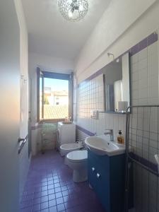 W łazience znajduje się umywalka, toaleta i lustro. w obiekcie Casa Mimmi - Pesaro Centro/Mare w mieście Pesaro