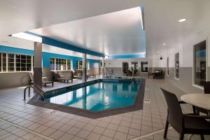 uma piscina no átrio do hotel com cadeiras e mesas em Sleep Inn Londonderry em Londonderry