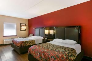 a hotel room with two beds and a red wall at Econo Lodge Amish Country in Lancaster