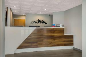 an office with a reception desk with a painting of mountains at SureStay Plus Hotel by Best Western Sevierville in Sevierville