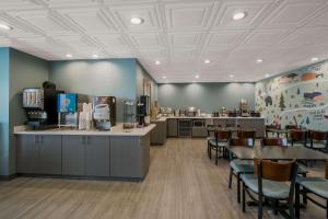 a waiting room with tables and chairs in a restaurant at SureStay Plus Hotel by Best Western Sevierville in Sevierville