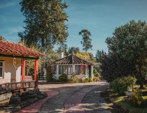 a house with a brick road next to a building at Hotel Finca el Recreo in Guasca