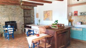 cocina con mesa y chimenea de piedra en Ty Monde - Chambres d'hôtes en Finistère, en Poullaouen