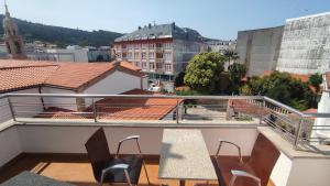 a balcony with chairs and a view of a city at Villa Xunqueira 3 in Cee