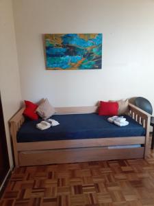1 cama con sábanas azules y almohadas rojas en una habitación en Vicente López Fresh en Vicente López