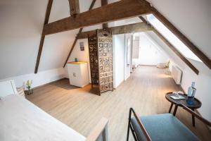 um quarto no sótão com piso de madeira e vigas de madeira em Ty Monde - Chambres d'hôtes en Finistère em Poullaouen