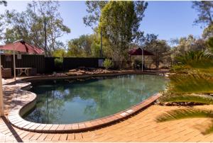 a large swimming pool with a brick walkway around it at Discovery Resorts - Kings Canyon in Kings Canyon