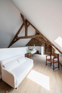 sala de estar con sofá blanco y mesa en Ty Monde - Chambres d'hôtes en Finistère, en Poullaouen