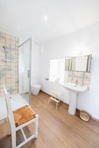 uma casa de banho branca com um lavatório e um chuveiro em Ty Monde - Chambres d'hôtes en Finistère em Poullaouen