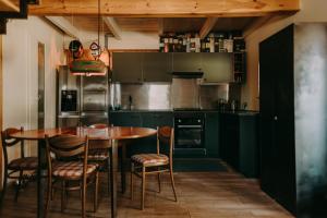 NadoleにあるBiker's Houseのキッチン(緑のキャビネット、テーブル、椅子付)