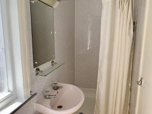 a bathroom with a sink and a shower curtain at Seaclyffe Hotel Ltd in Llandudno