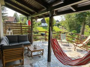 een patio met een hangmat en een tafel en stoelen bij Kuća za odmor PIKA in Duga Resa