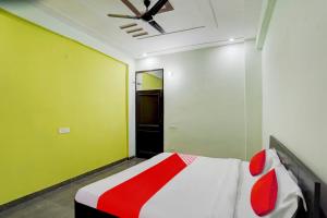 Schlafzimmer mit einem Bett und einem Deckenventilator in der Unterkunft OYO Flagship J M K Love Residency in Noida