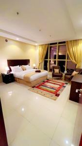 a bedroom with a bed and a couch and a chair at راما للاجنحة الفندقية in Jeddah