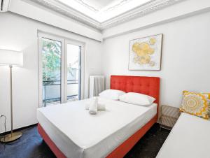 アテネにあるAcropolis View Dream Apartmentsのベッドルーム1室(赤いヘッドボード付きの大型ベッド1台付)