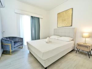 1 dormitorio con 1 cama blanca y 1 silla azul en Acropolis View Dream Apartments, en Atenas