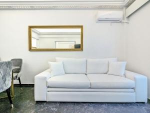 a white couch in a living room with a mirror at Acropolis View Dream Apartments in Athens