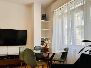 ein Wohnzimmer mit einem Tisch und Stühlen sowie einem TV in der Unterkunft Vaibar Apartaments en el centro de Vigo entorno plaza de Compostela in Vigo