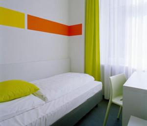 Un pat sau paturi într-o cameră la Colour Hotel