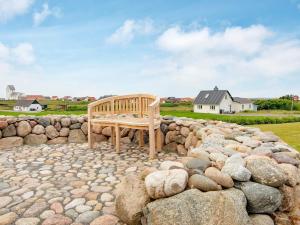 un banco de madera sentado sobre un montón de rocas en Holiday home Lemvig XXX, en Lemvig