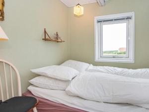 Schlafzimmer mit einem Bett mit weißer Bettwäsche und einem Fenster in der Unterkunft Holiday home Lemvig XXX in Lemvig