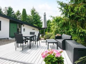 een patio met een tafel en stoelen en een parasol bij Holiday home Ebeltoft CLXXXI in Ebeltoft
