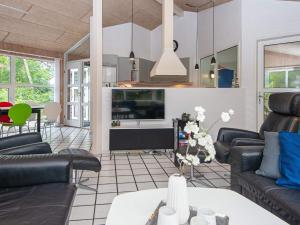 a living room with couches and a tv at Holiday home Glesborg VI in Glesborg